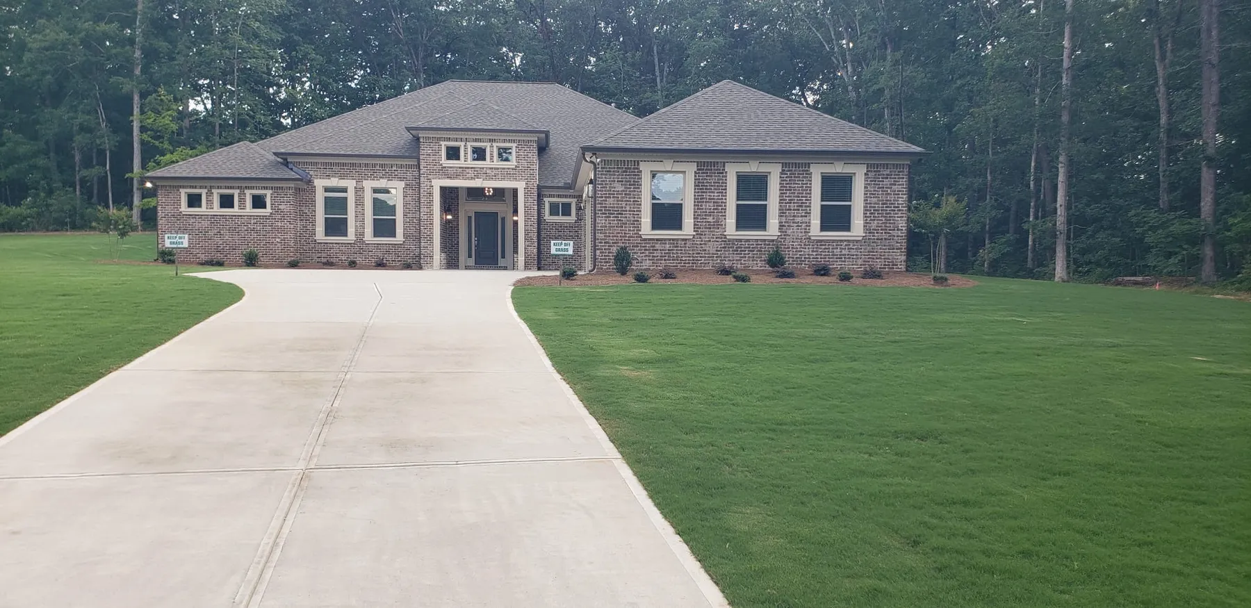 Completed brick home with a long concrete driveway built by Peters Prestigious Properties Inc.